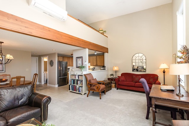 living area with an AC wall unit, a notable chandelier, a towering ceiling, and light carpet