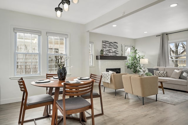 dining room featuring recessed lighting, a brick fireplace, light wood-style flooring, and baseboards