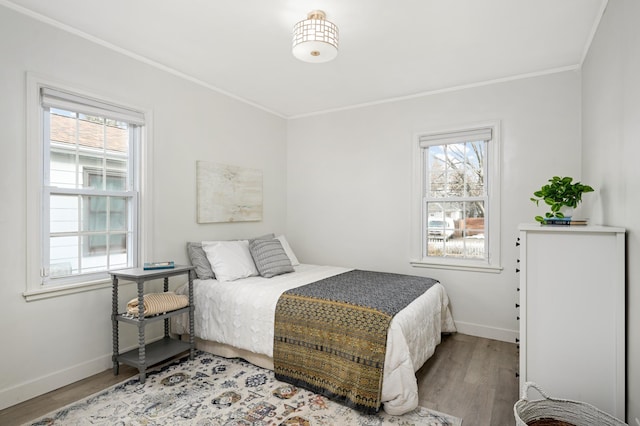 bedroom with light wood finished floors, baseboards, and crown molding