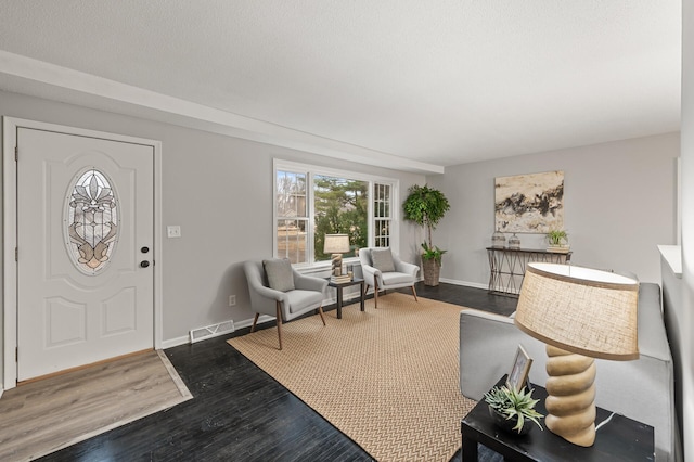 entryway with baseboards, visible vents, and dark wood-style flooring