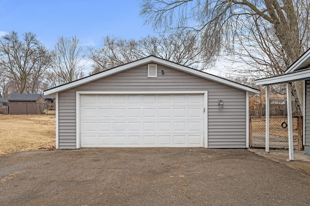 detached garage featuring fence