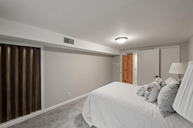 carpeted bedroom with a textured ceiling, visible vents, and baseboards