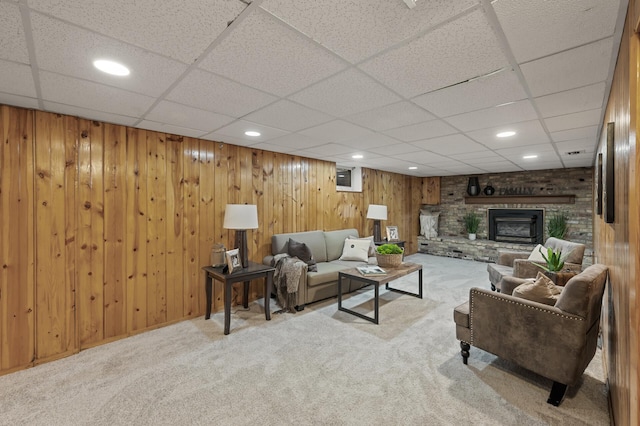 carpeted living room featuring wood walls, a brick fireplace, and recessed lighting