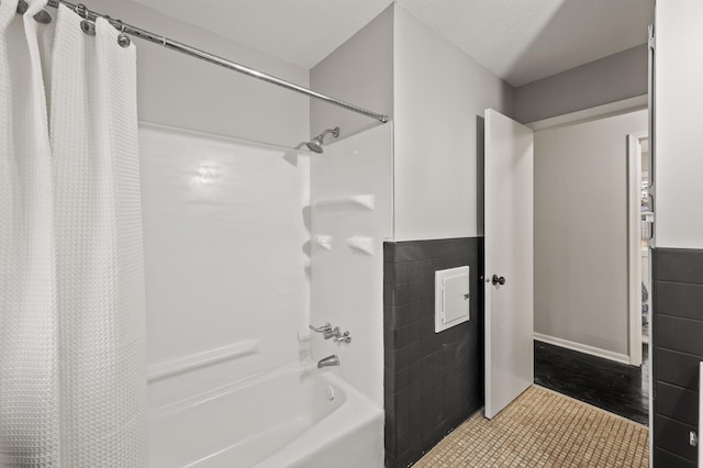 full bathroom featuring shower / tub combo, tile walls, a textured ceiling, and tile patterned floors