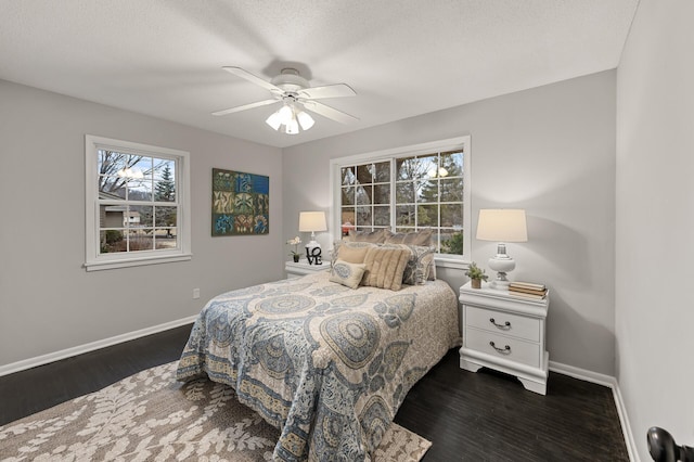 bedroom featuring dark wood-type flooring, ceiling fan, and baseboards