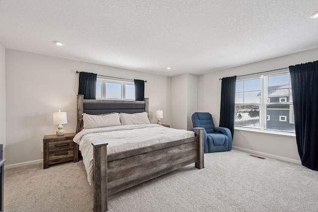 bedroom with visible vents, light carpet, a textured ceiling, recessed lighting, and baseboards