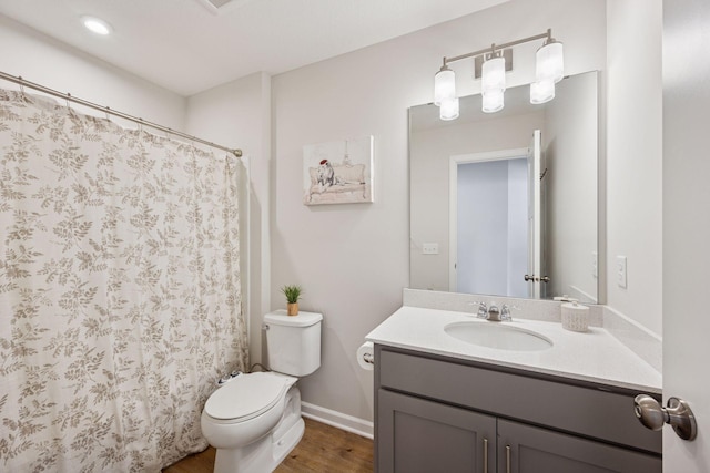 bathroom featuring curtained shower, baseboards, toilet, wood finished floors, and vanity