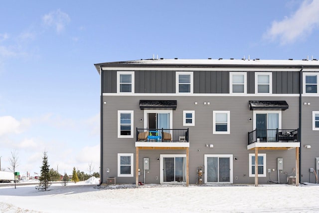 snow covered property with central AC unit