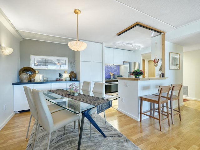 dining area with visible vents and light wood-style flooring