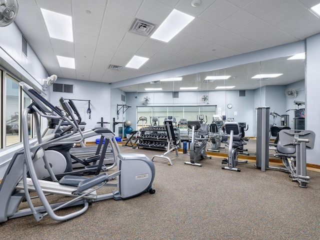 workout area featuring a paneled ceiling, visible vents, and baseboards