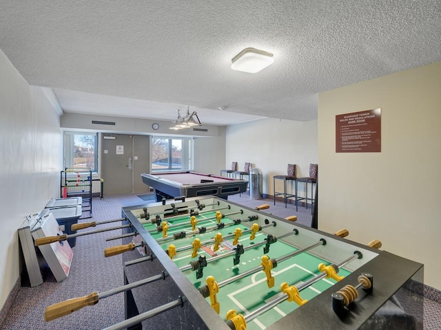 rec room with baseboards, visible vents, and a textured ceiling