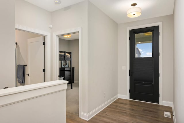 entrance foyer featuring baseboards, visible vents, and dark wood-style flooring