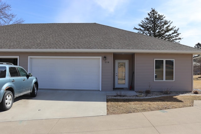 view of front of property featuring roof with shingles, concrete driveway, and an attached garage