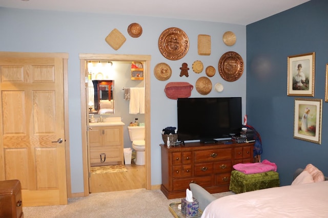 bedroom featuring ensuite bath, carpet, and a sink