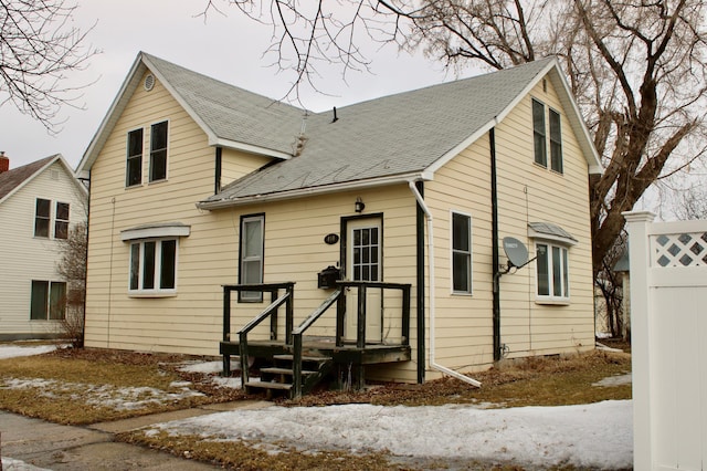 traditional home featuring roof with shingles