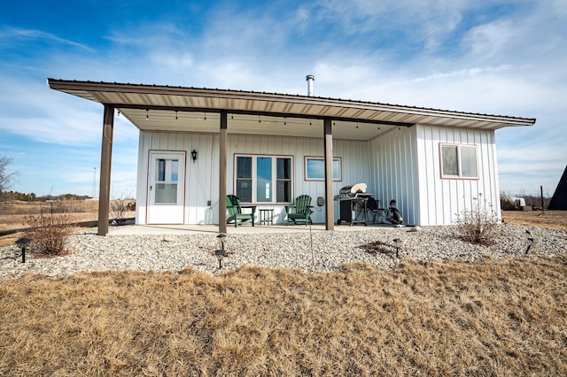 rear view of house featuring metal roof and board and batten siding