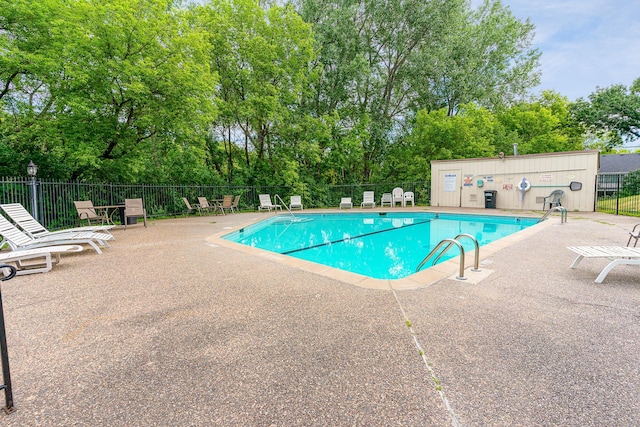 pool featuring fence and a patio area