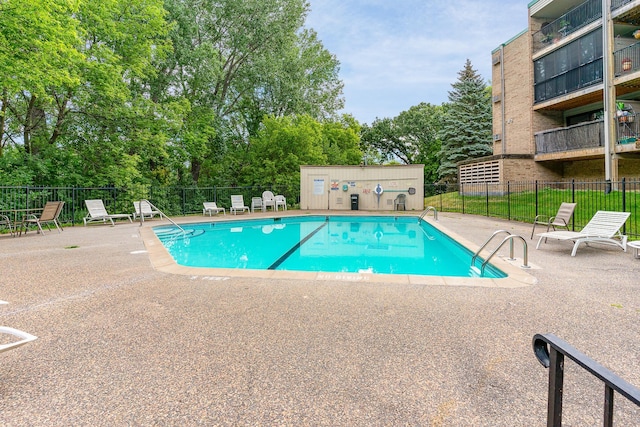 pool with a patio area and fence