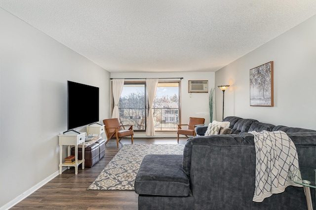 living room featuring baseboards, a textured ceiling, an AC wall unit, and dark wood-style flooring