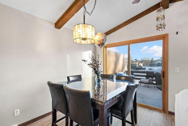 dining space featuring a notable chandelier, lofted ceiling with beams, a textured ceiling, wood finished floors, and baseboards