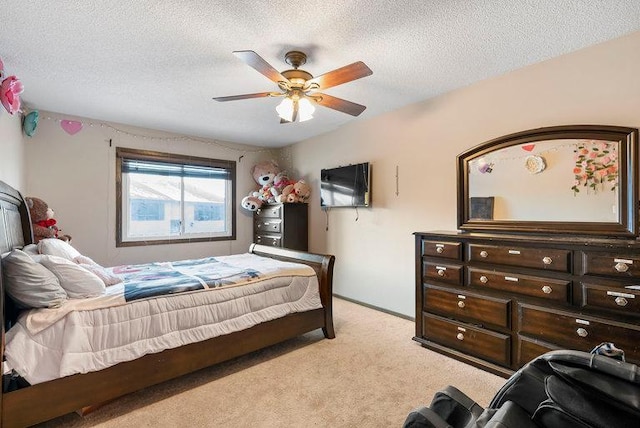 bedroom featuring light colored carpet, ceiling fan, and a textured ceiling