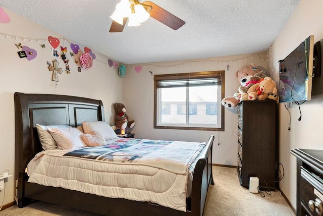 bedroom featuring light colored carpet, ceiling fan, a textured ceiling, and baseboards