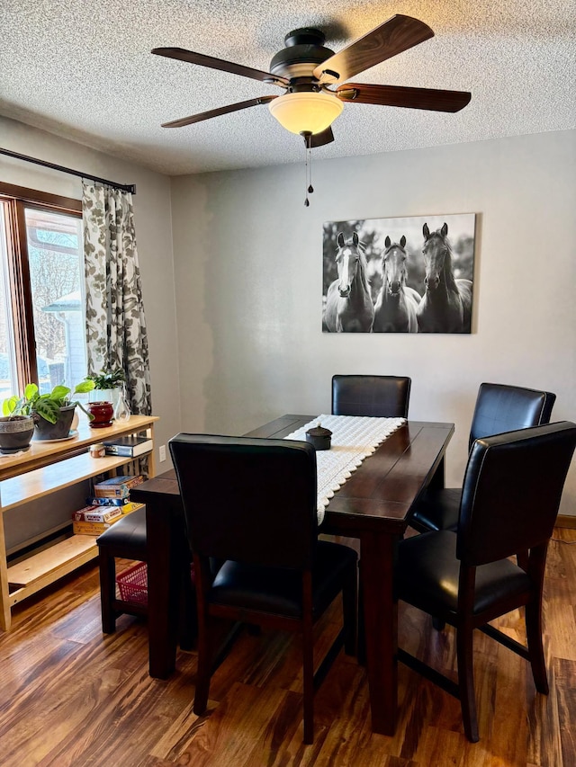 dining room with a textured ceiling and wood finished floors