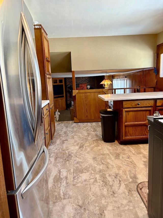 kitchen featuring brown cabinetry, light countertops, and freestanding refrigerator