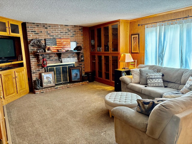 living room with wooden walls, ornamental molding, carpet, a textured ceiling, and a brick fireplace