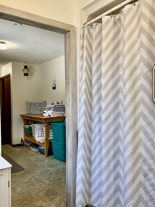 bathroom with a textured ceiling and a shower with shower curtain