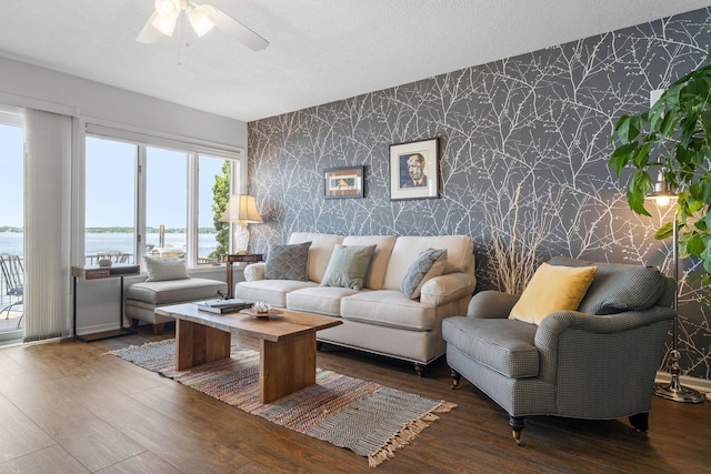 living area featuring wallpapered walls, a textured ceiling, and wood finished floors