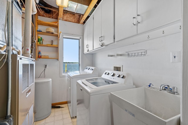 laundry room with cabinet space, light floors, a sink, and separate washer and dryer