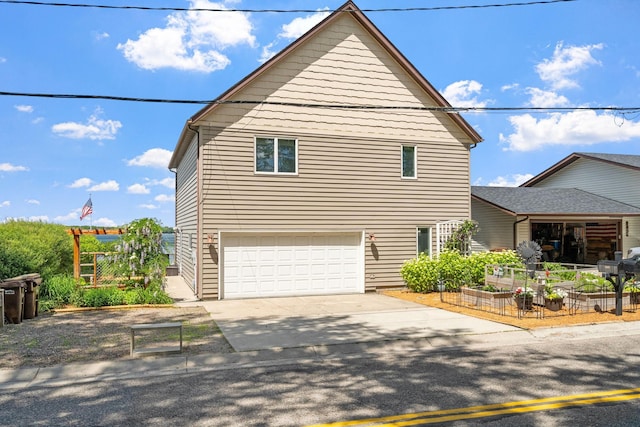 view of front of property with a garage, driveway, and a garden