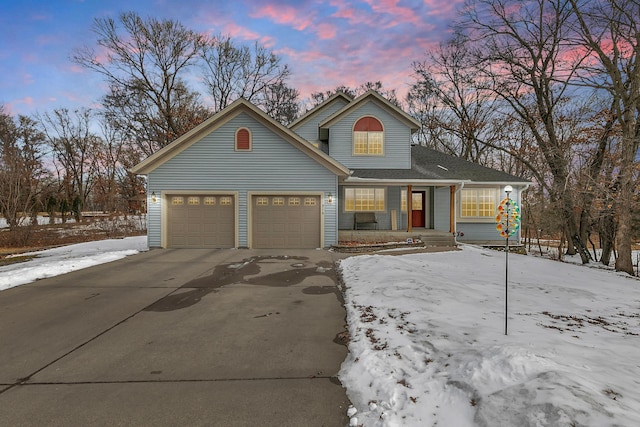 traditional-style house featuring concrete driveway, an attached garage, a porch, and a shingled roof