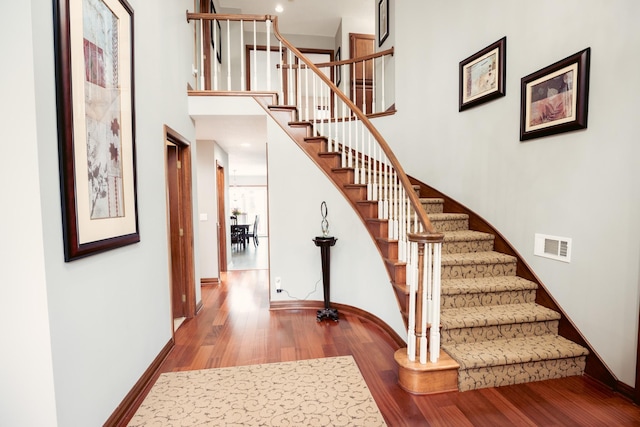 1301 12th Ave NW, New Brighton, MN 55112 - staircase with wood finished floors, baseboards, and a high ceiling