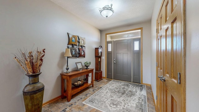 entrance foyer featuring baseboards and a textured ceiling