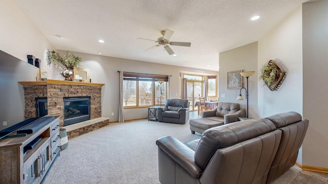 carpeted living room featuring a ceiling fan, baseboards, recessed lighting, a fireplace, and a textured ceiling