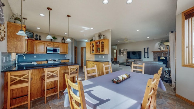 dining area featuring stone finish flooring, recessed lighting, baseboards, and ceiling fan