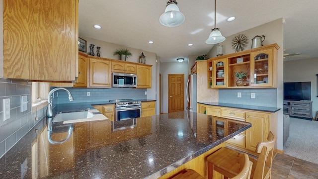 kitchen featuring a sink, stainless steel appliances, dark stone countertops, and decorative backsplash