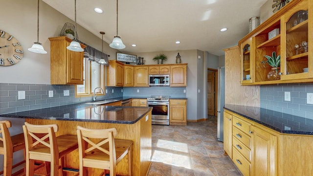 kitchen featuring a sink, a peninsula, tasteful backsplash, and stainless steel appliances