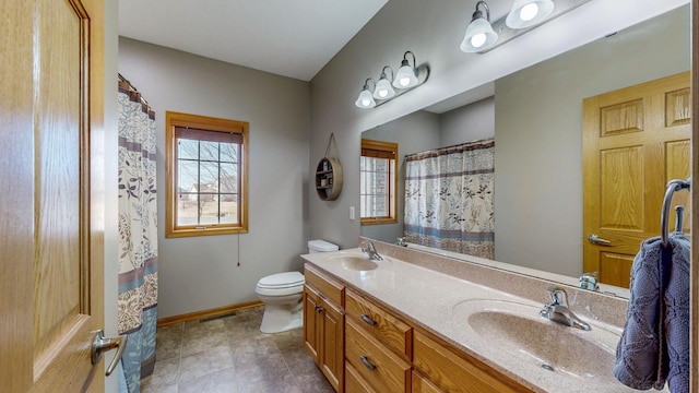 bathroom with toilet, visible vents, baseboards, and a sink