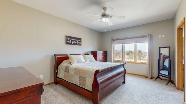 bedroom featuring light colored carpet, baseboards, and ceiling fan