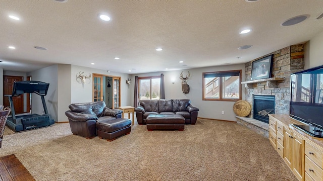 living room with baseboards, a textured ceiling, a fireplace, and carpet flooring