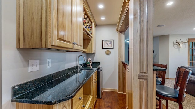 bar with a sink, dark wood-style floors, recessed lighting, indoor wet bar, and baseboards