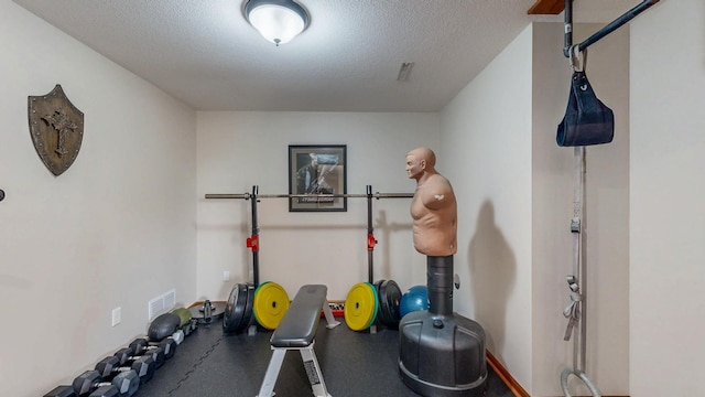 workout area with visible vents and a textured ceiling