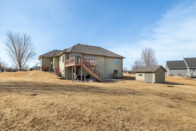 back of house featuring a storage unit, a lawn, an outdoor structure, a wooden deck, and stairs