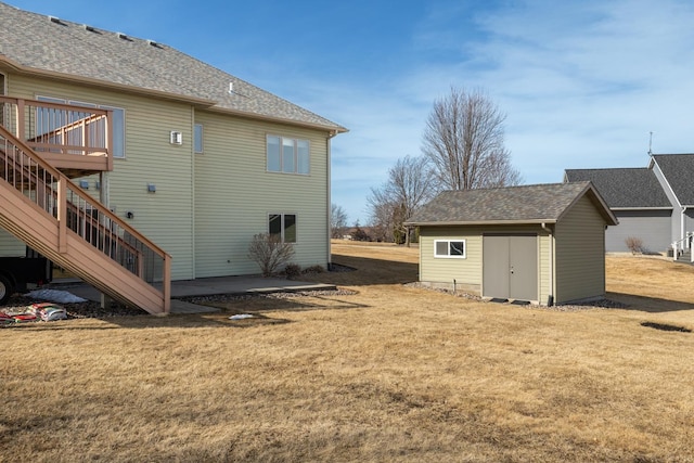 view of home's exterior featuring a lawn, an outdoor structure, stairs, and a patio area