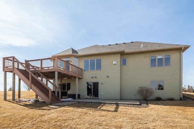 rear view of property with a patio, stairway, a yard, a shingled roof, and a wooden deck