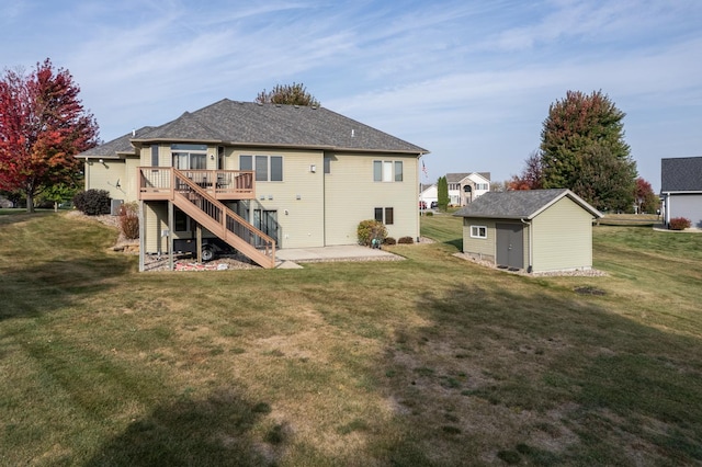 back of house featuring a lawn, an outdoor structure, a wooden deck, stairs, and a patio area