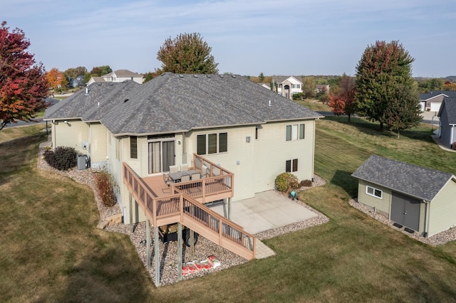 rear view of house featuring a lawn, a storage shed, a deck, an outdoor structure, and a patio area